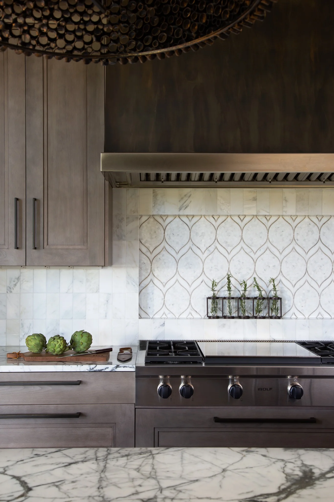 Wolf range in a luxury kitchen with marble backsplash and custom cabinetry